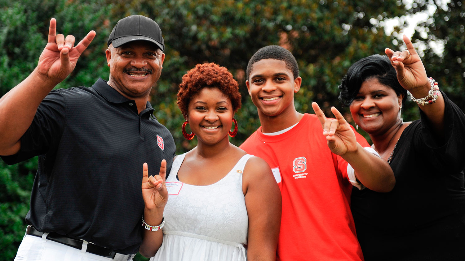 An NC State family giving the wolf sign