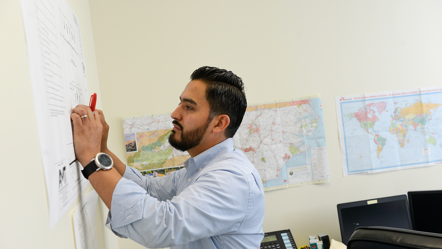 An NC State graduate student at work in his office.