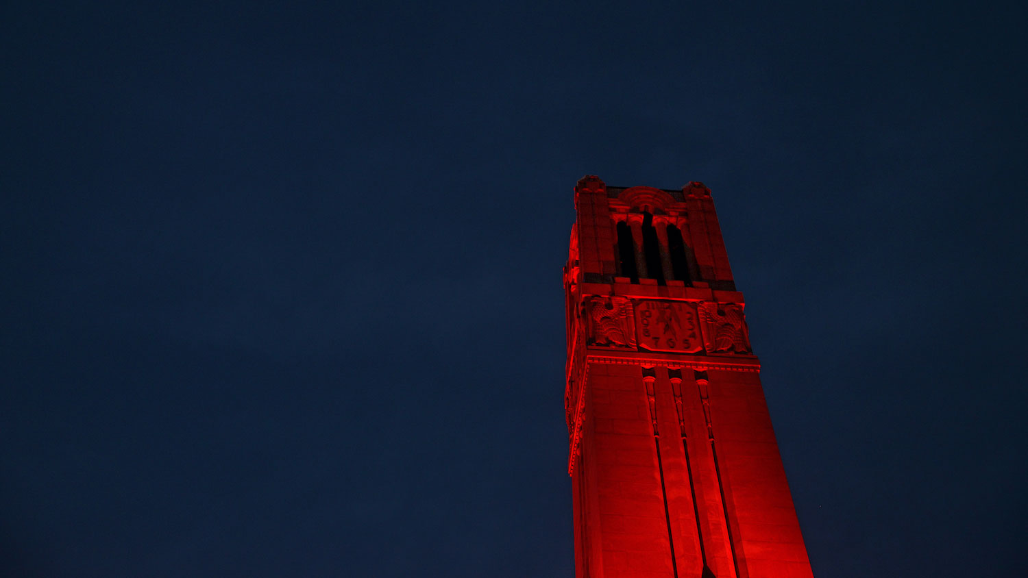 the memorial belltower illuminated red at night