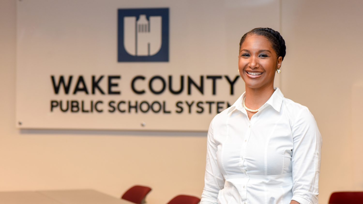 LaTeisha Jeannis in front of Wake County Public School System sign