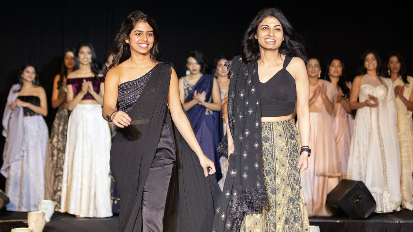 Ritika Shamdasani, left, and her sister Niki walk a fashion runway