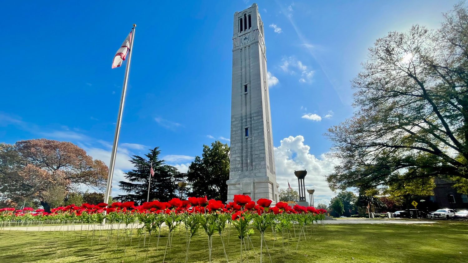The Belltower with flowers in the foreground, during a sunny day.