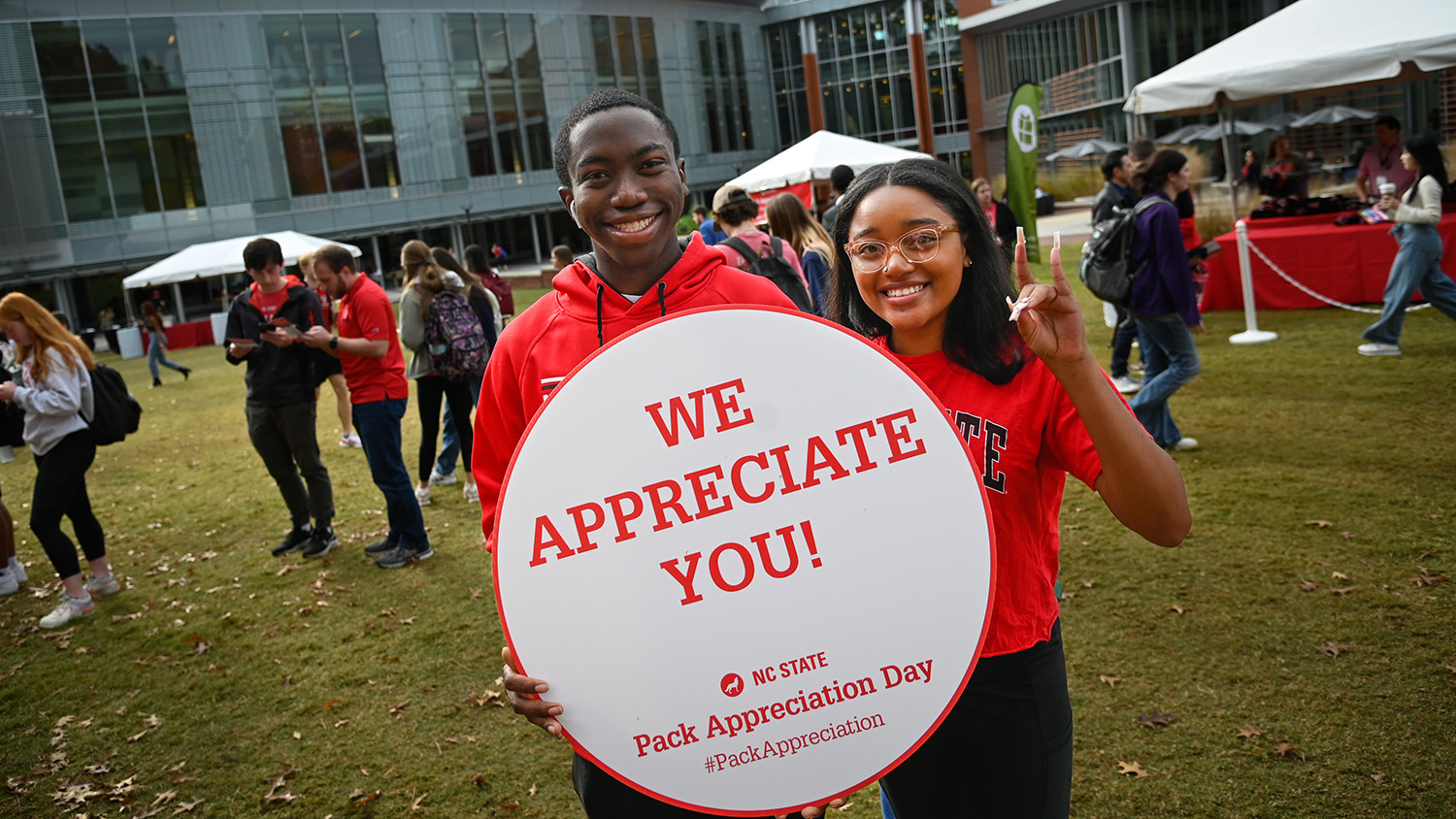 two students hold up a "We appreciate you sign" on Stafford Commons