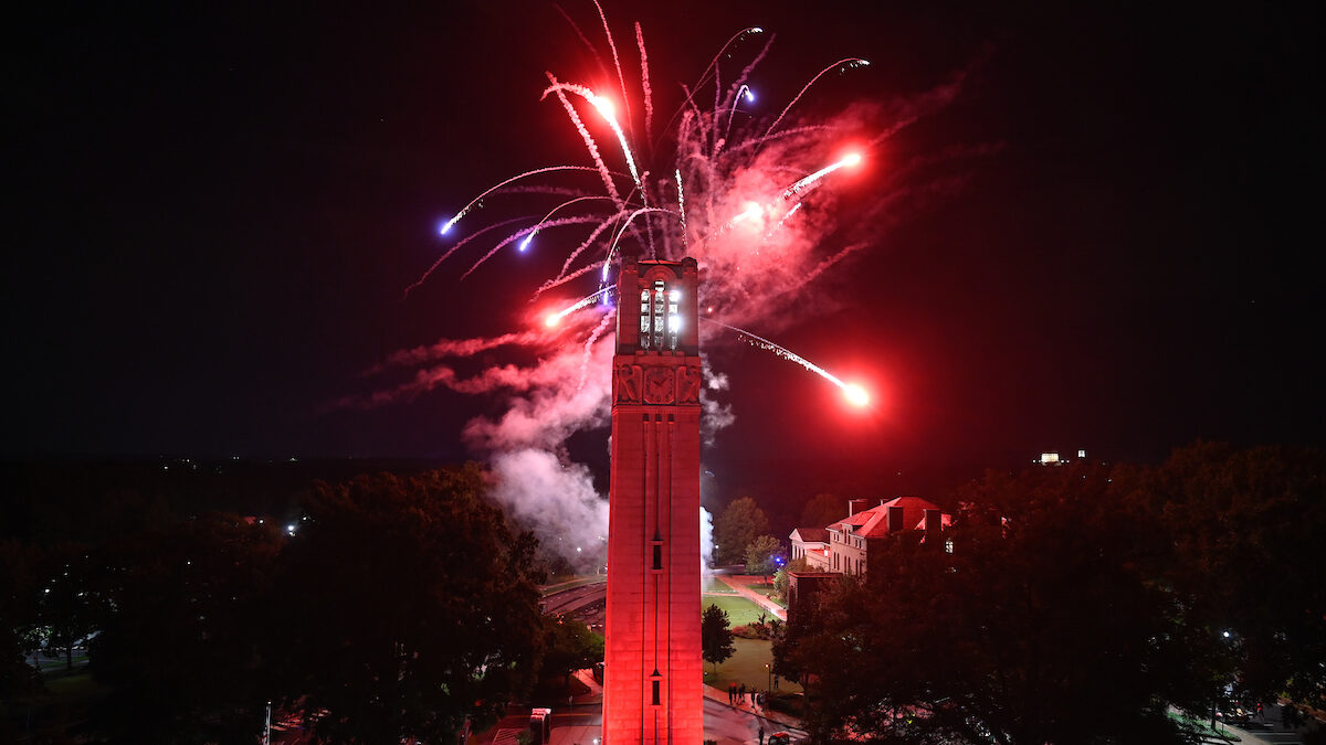 the belltower lit red with fireworks exploding behind it