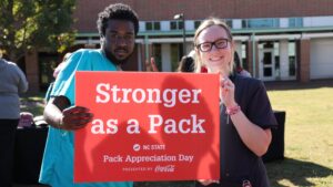 Two CVM students hold a sign that says stronger as a pack