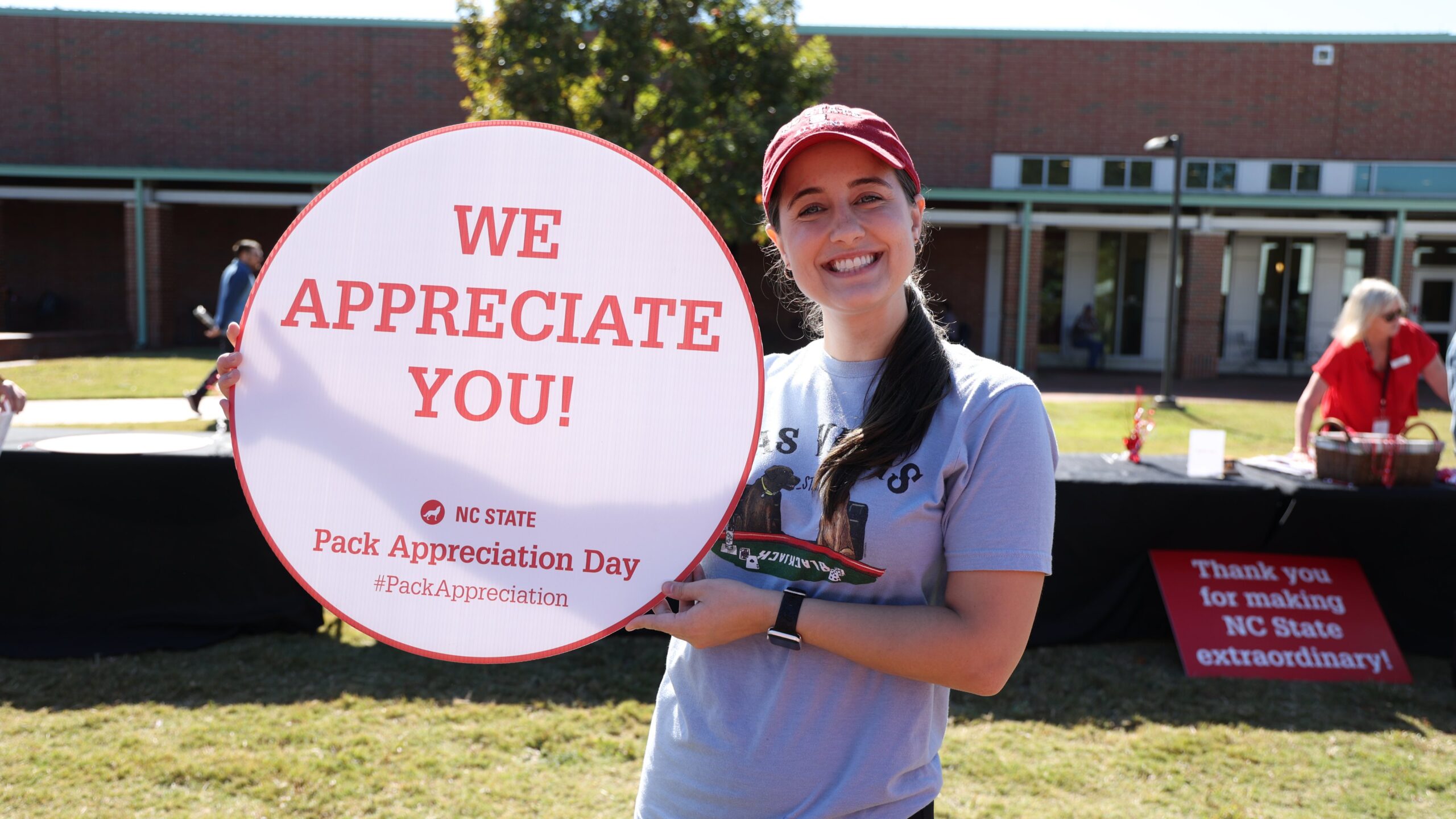A CVM student holds a round Pack Appreciation Day sign saying we appreciate you