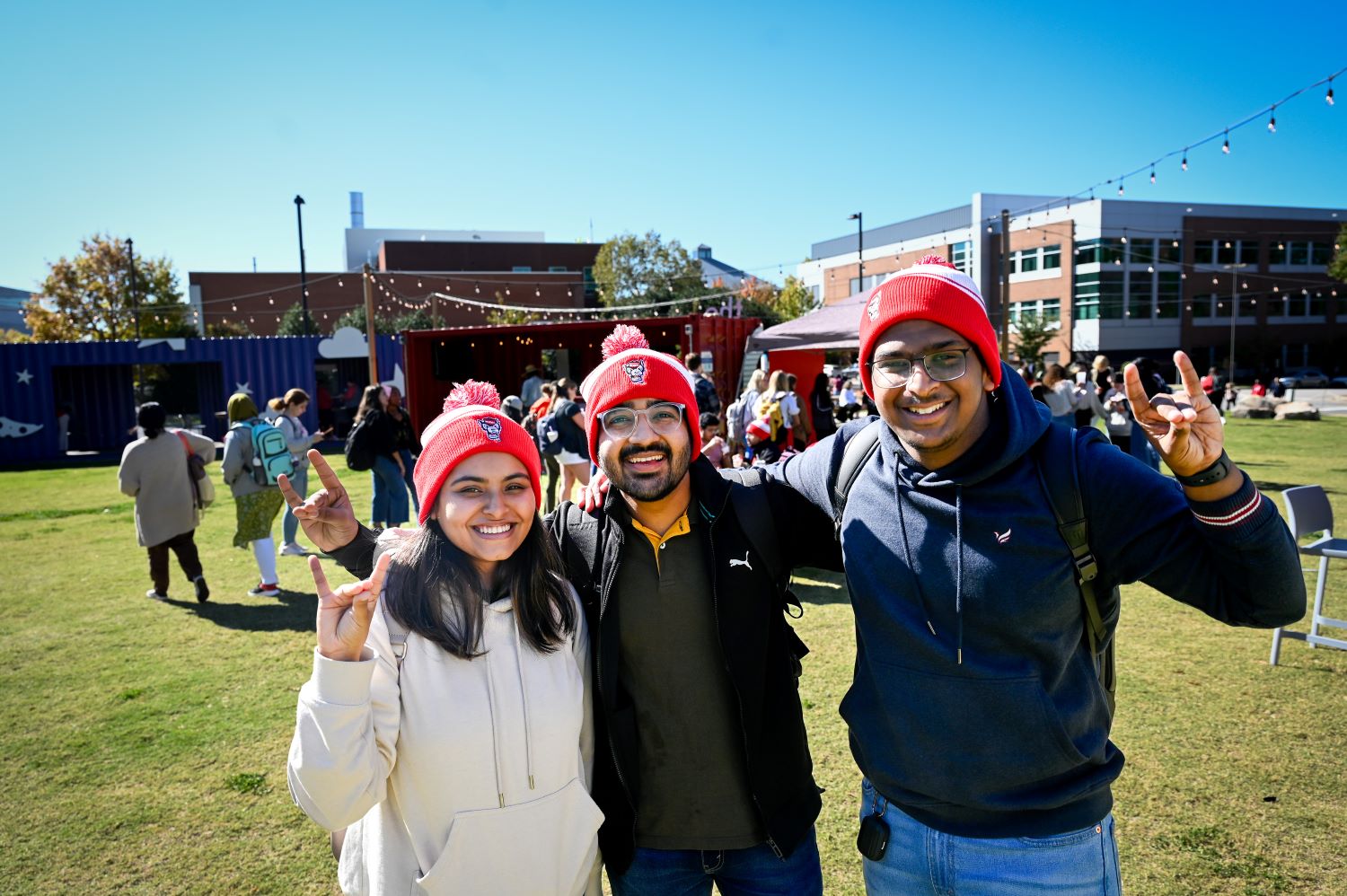 friends posing on Centennial campus in Pack Appreciation beanies