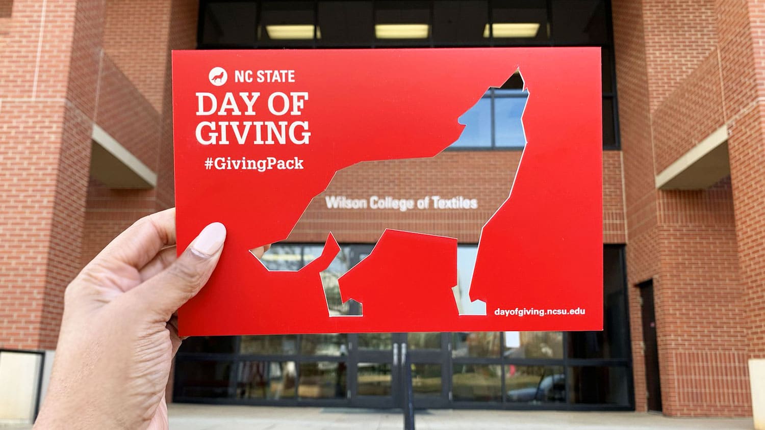 Day of Giving wolf cutout in front of Wilson College of Textiles building