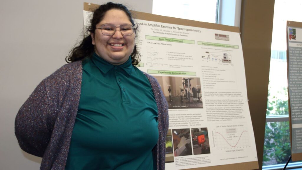 Terry Chavez posing with a poster presentation