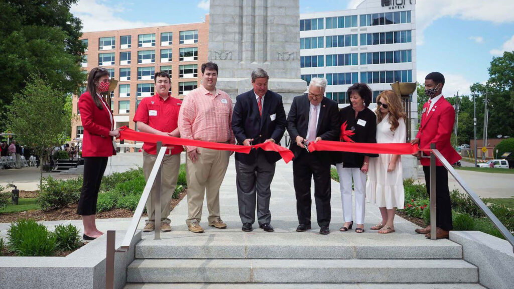 Chancellor Randy Woodson and the Henry family cut the ribbon dedicating the Henry Square and reopening the Memorial Belltower.