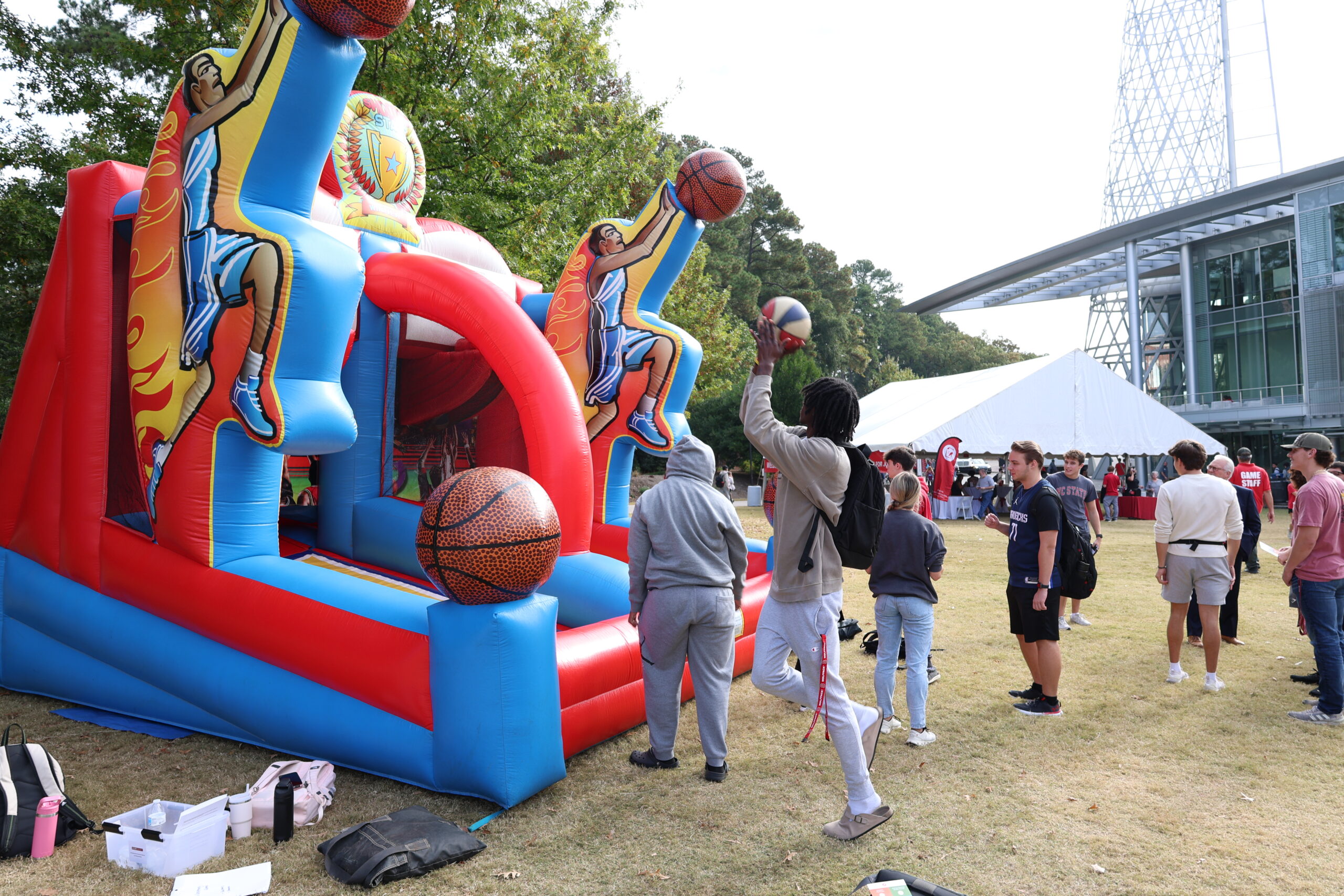 A student shooting a basket at an inflatable hoop.