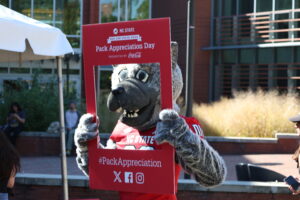 Mr. Wuf holding a Pack Appreciation photo frame.