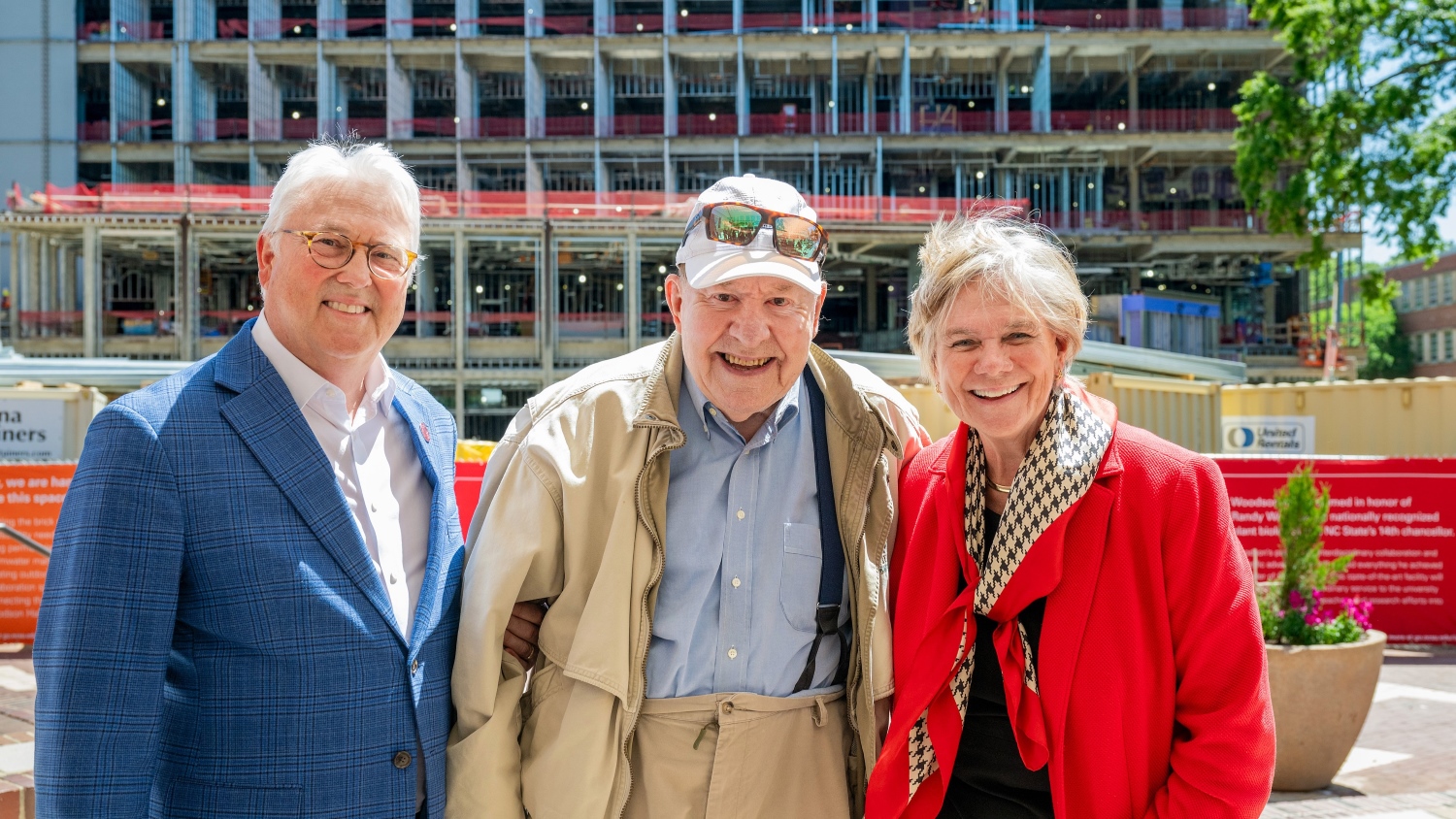 Randy Woodson, Tom Kenan and Nancy Cable pose in front of Woodson Hall construction