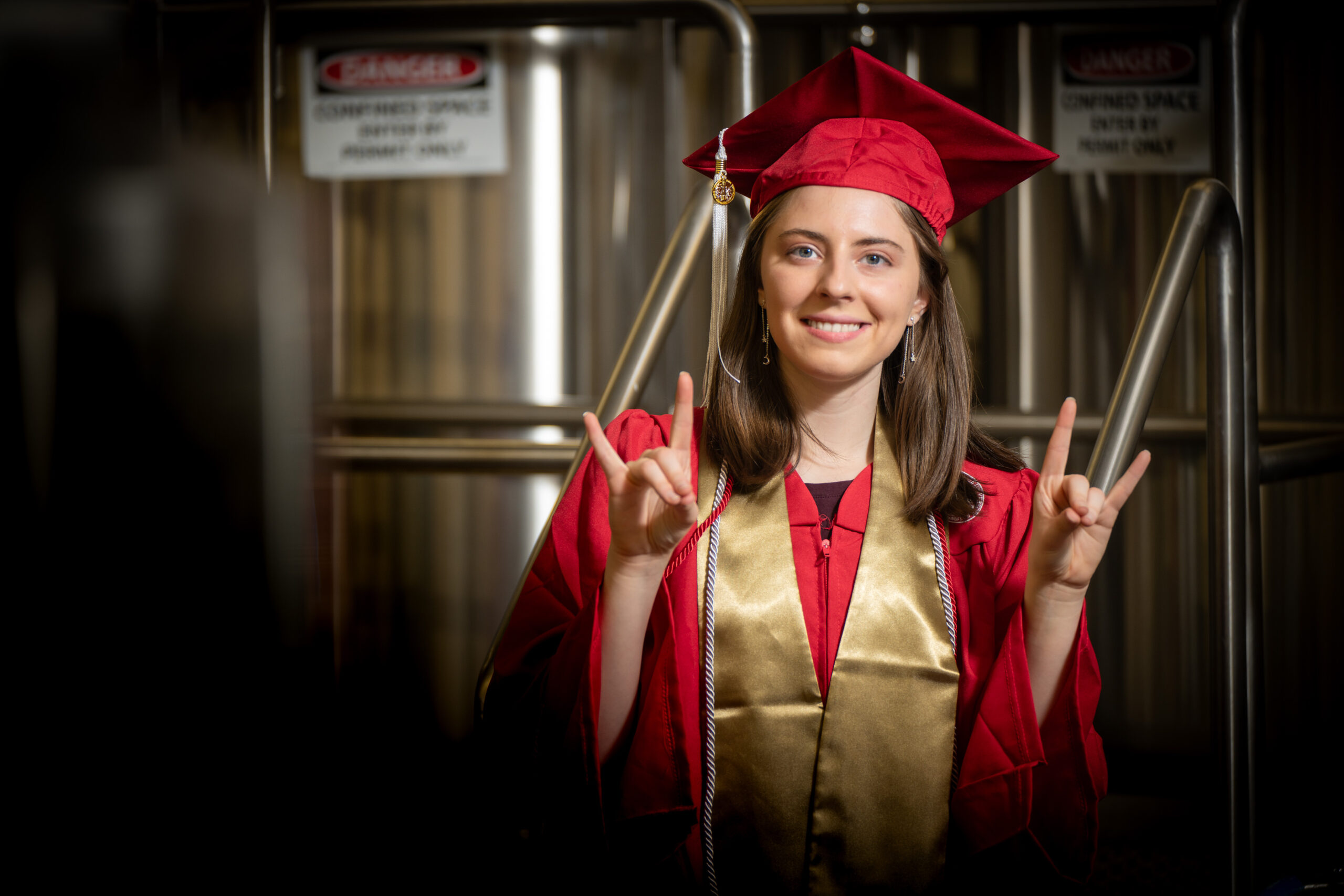 Beth Liles does the the wolfie in her cap and gown