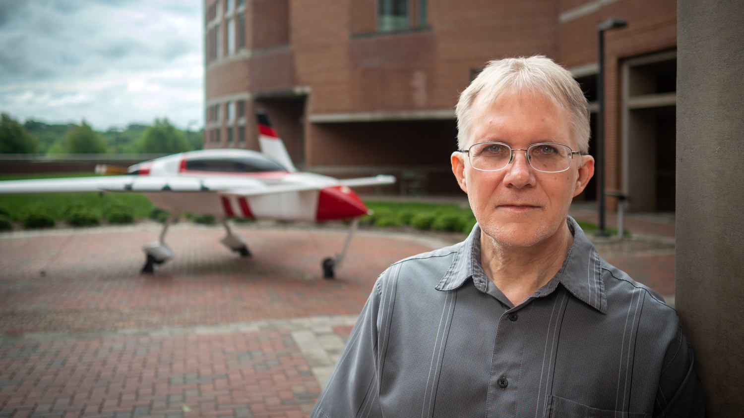 Professor Jack Edwards standing in front of an airplane on Centennial Campus.